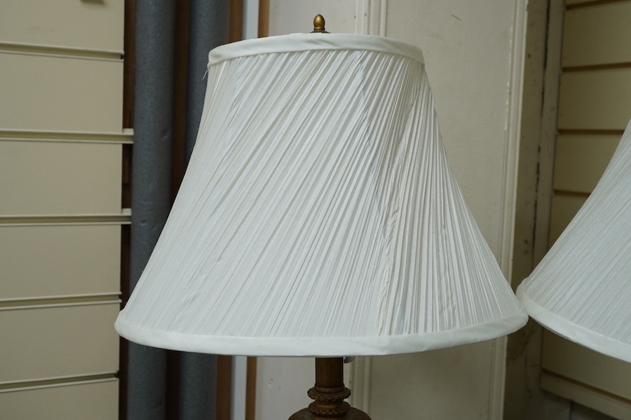 A pair of gilt resin table lamps with white shades, 76cm high. Condition - fair to good.